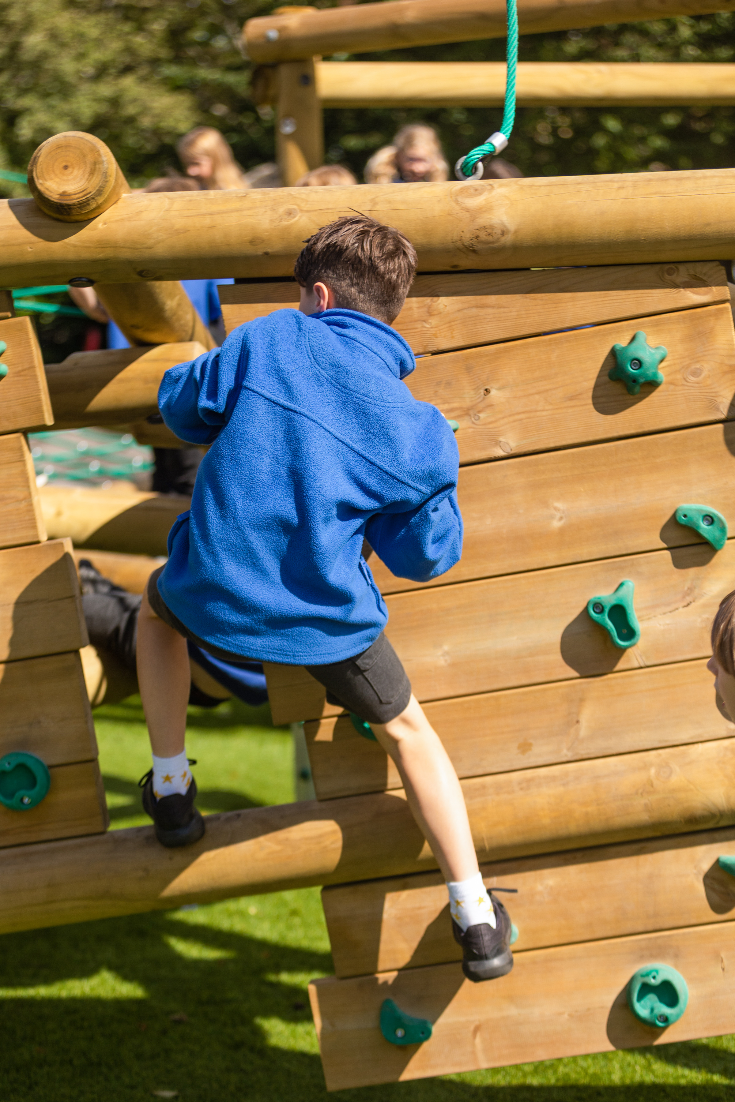 Child on wooden outdoor climbing wall