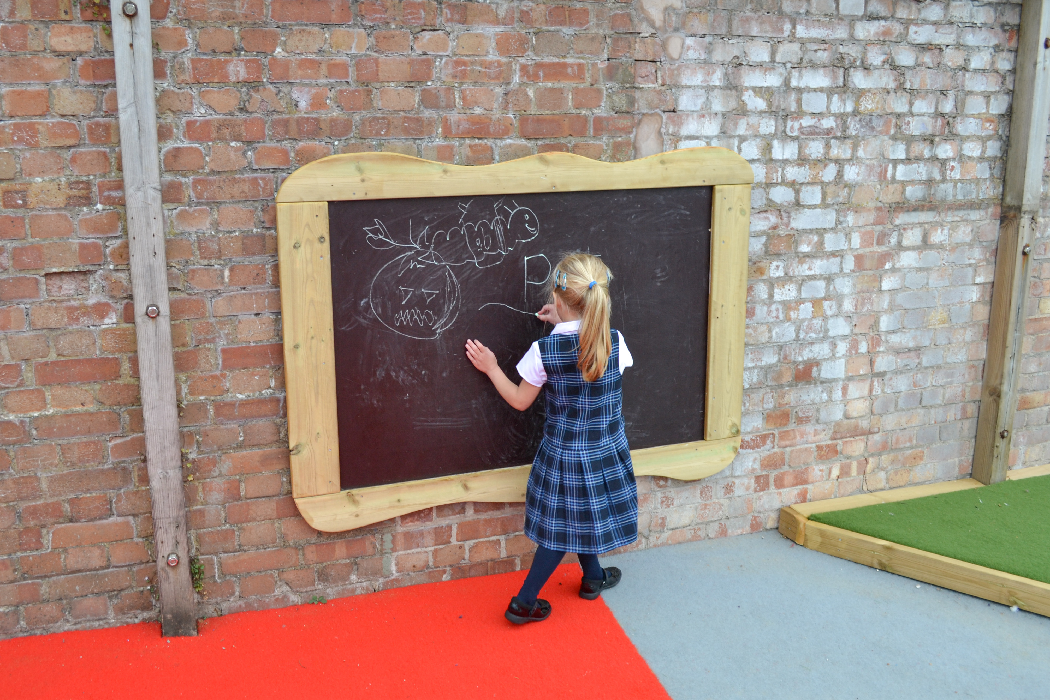 Child drawing on outdoor chalkboard