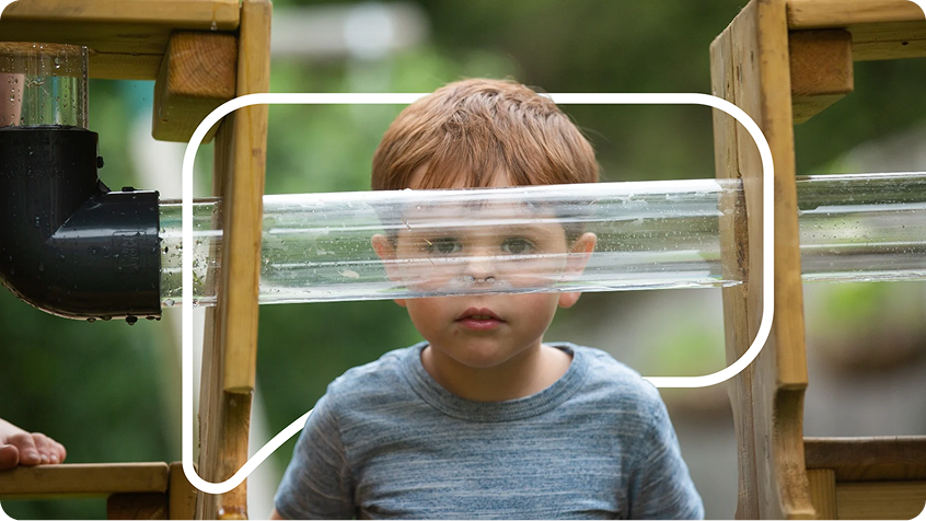 Child looking through water tube