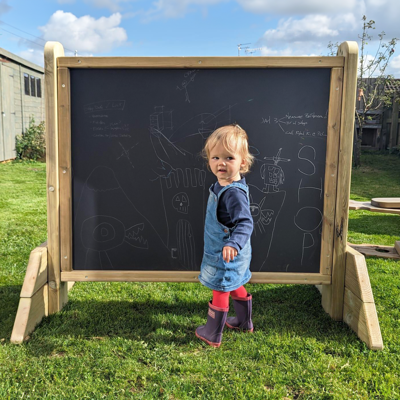 Child in front of outdoor blackboard