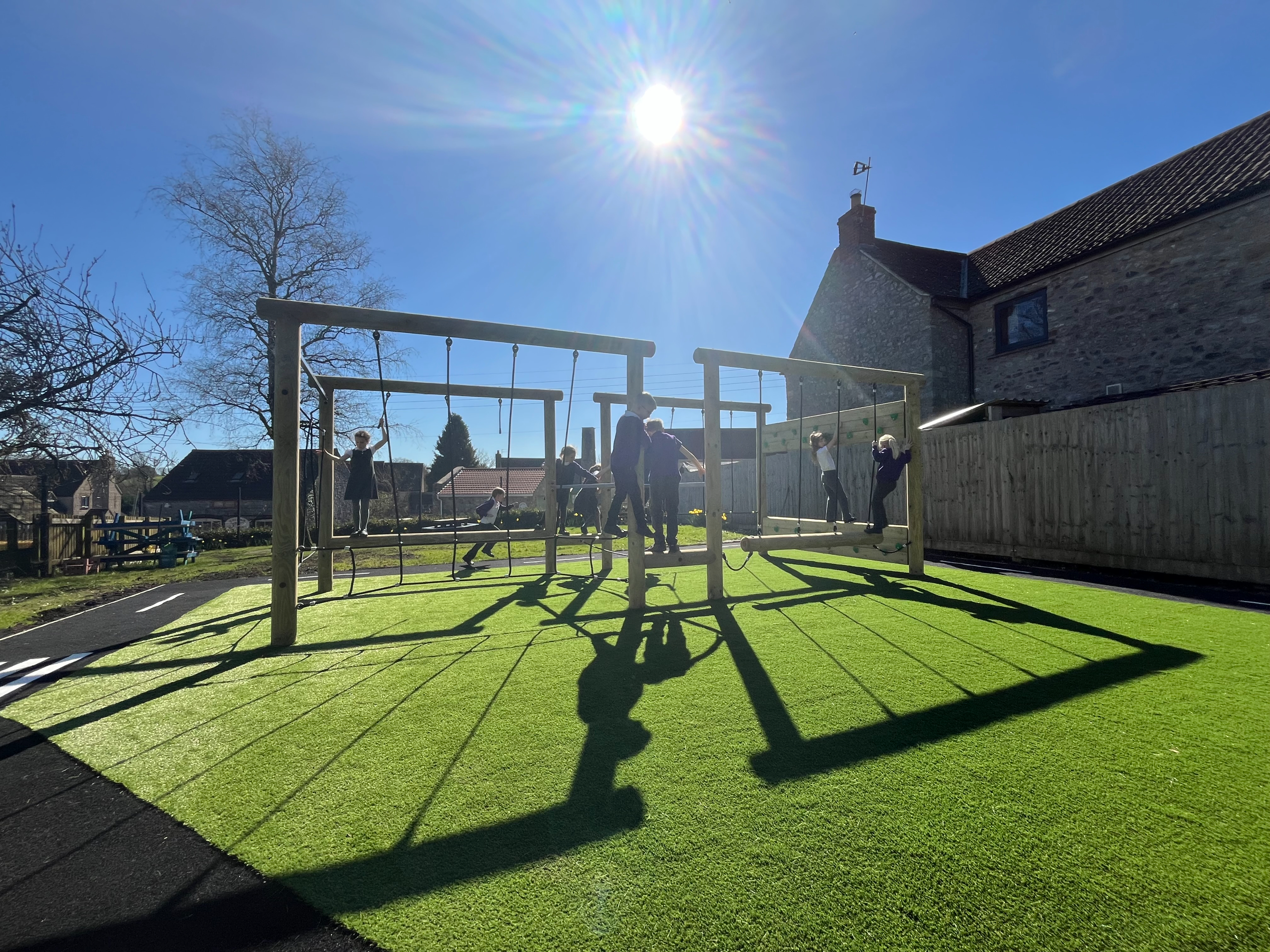 School Playground Design showing children playing on a Lemur Rig and surrounding roadway - Leigh on Mendip School
